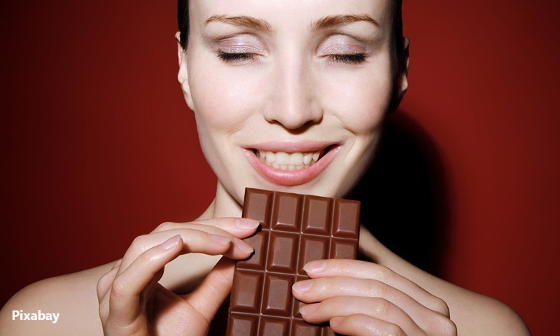 alt="woman eating dark chocolate"