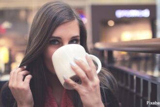alt="woman drinking coffee"